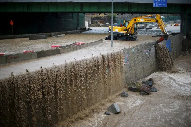 An excavator mounted with a hammer works on flooded street in Santiago, April 17, 2016. (Photo by Ivan Alvarado/Reuters)