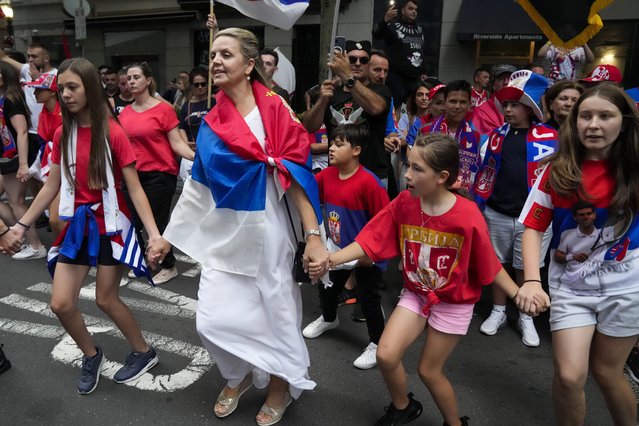 Fans dance and sing outside an immigration detention hotel where Serbian Novak Djokovic is confined in Melbourne, Australia, Monday, January 10, 2022. (Photo by Mark Baker/AP Photo)