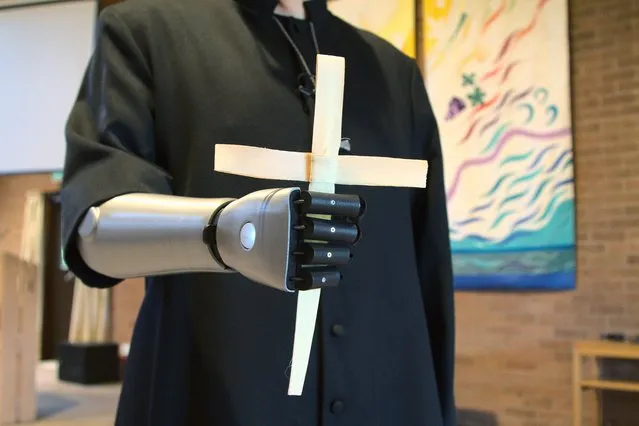 Priest-in-training Daniel Cant holds a cross as he demonstrates his bionic arm by British company Open Bionics at Christ Church in Colchester, Essex, Britain on March 30, 2021. (Photo by Stuart McDill/Reuters)
