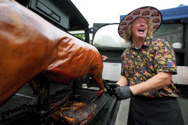 Brad Orrison, of The Shed BBQ and Blues Joint team, laughs as a whole hog is pulled from his cooker at the World Championship Barbecue Cooking Contest, Saturday, May 18, 2024, in Memphis, Tenn. (Photo by George Walker IV/AP Photo)
