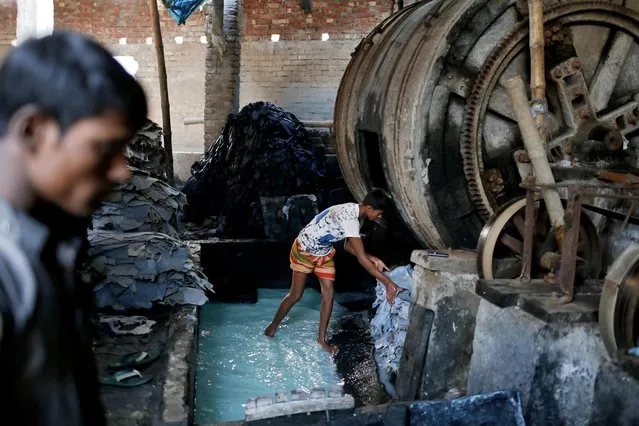 In this Monday, February 6, 2017 photo, a Bangladeshi boy processes animal hide inside a factory at the highly polluted Hazaribagh tannery area in Dhaka, Bangladesh. (Photo by A.M. Ahad/AP Photo)