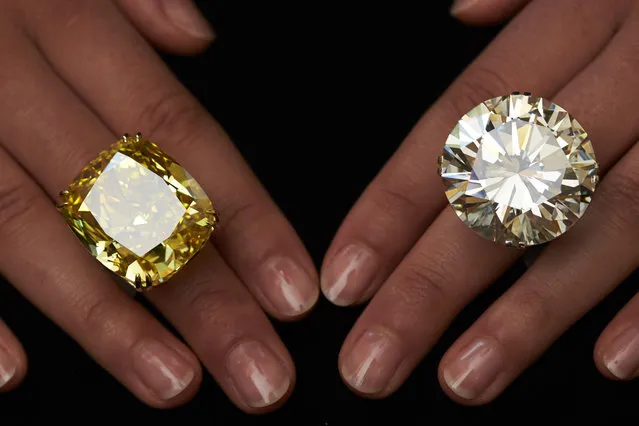 A model poses with a vivid yellow 100.09 carats diamond (L) and a 103.46 carats diamond ring during an auction preview at Sotheby's in Geneva May 7, 2014. These items are expected to reach between CHF 13,250,000 to 22,250,000 (USD 15,000,000 to 25,000,000) and CHF 3,100,00 and 4,450,000 (USD 3,500,00 to 5,000,000) when they go on sale May 13, 2014 in Geneva. (Photo by Denis Balibouse/Reuters)