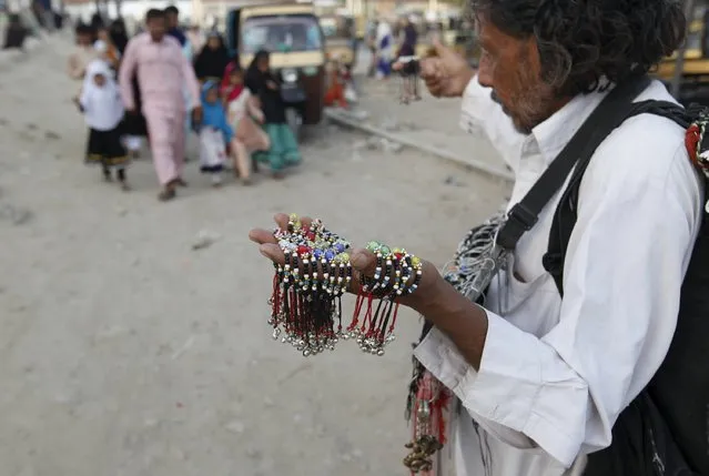A man sells decorative accessories for children along a road in Karachi, Pakistan, April 22, 2016. (Photo by Akhtar Soomro/Reuters)