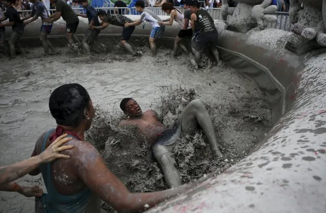 Tourists play in a mud pool during the Boryeong Mud Festival at Daecheon beach in Boryeong, South Korea, July 18, 2015. (Photo by Kim Hong-Ji/Reuters)