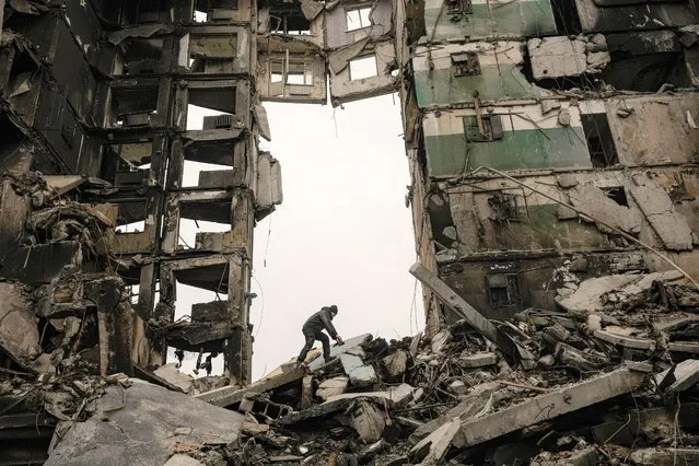 A resident looks for belongings in the ruins of an apartment building destroyed during fighting between Ukrainian and Russian forces in Borodyanka, Ukraine, Tuesday, April 5, 2022. Ukrainian President Volodymyr Zelenskyy accused Russian troops of gruesome atrocities in Ukraine and told the U.N. Security Council on Tuesday that those responsible should immediately be brought up on war crimes charges in front of a tribunal like the one set up at Nuremberg after World War II. (Photo by Vadim Ghirda/AP Photo)