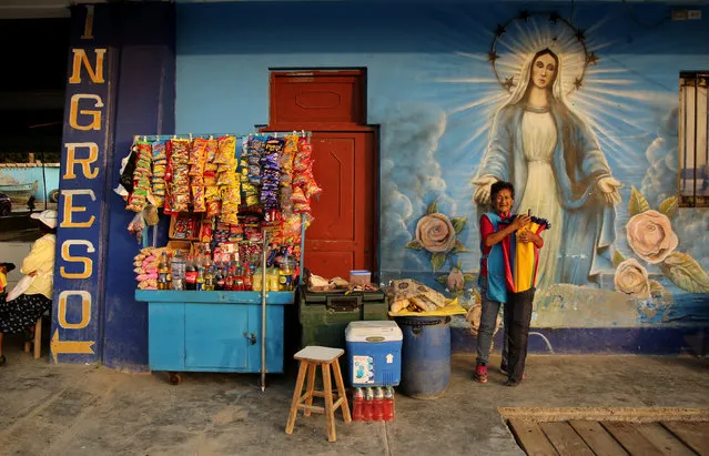 A woman sells candy at a fish market in Chorrillos district of Lima, Peru, May 18, 2017. (Photo by Mariana Bazo/Reuters)