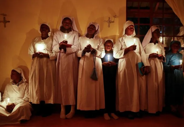 Worshipers hold candles during Easter vigil prayers at the St. Joanes, Legio Maria of African Church Mission within Fort Jesus in Kibera district of Nairobi, Kenya on April 17, 2022. (Photo by Thomas Mukoya/Reuters)