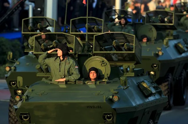 A soldier salutes from an armored vehicle at military parade in downtown of Zagreb, Croatia, August 4, 2015. The parade marks the 20th anniversary of Operation Storm, Victory Day, Homeland Thanksgiving Day and Day of Croatian defenders. (Photo by Antonio Bronic/Reuters)