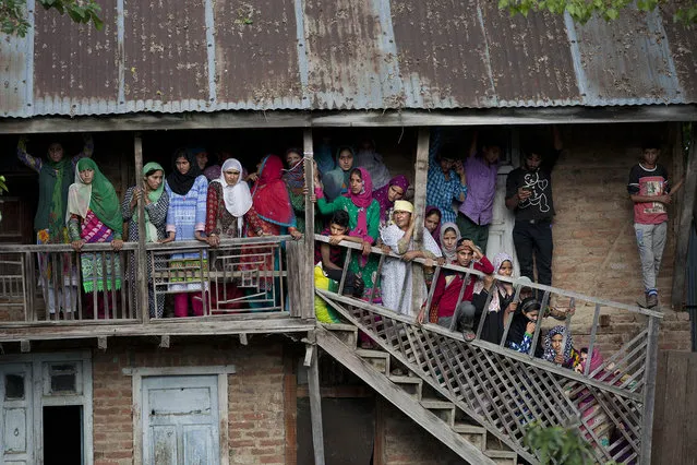 Kashmiri Muslims watch the funeral procession of Altaf Ahmed, a suspected militant, during his funeral procession in Brath village, 60 kilometers (38 miles) north of Srinagar, Indian controlled Kashmir, Friday, June 17, 2016. Ahmed was killed in a gun battle with Indian forces in the northern town of Bomai. (Photo by Dar Yasin/AP Photo)