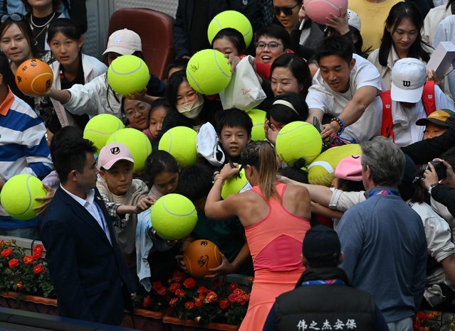 Spain's Paula Badosa gives her autograph to fans after winning against China's Zhang Shuai during their women's singles quarterfinal match at the China Open tournament in Beijing on October 3, 2024. (Photo by Adek Berry/AFP Photo)