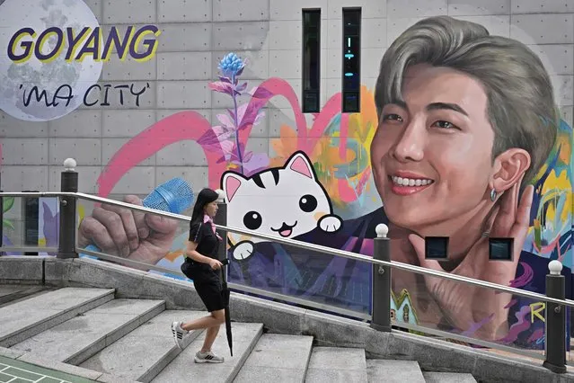 A woman walks past a mural depicting RM, a member of K-pop group BTS, in Goyang, northwest of Seoul, on June 15, 2022. (Photo by Anthony Wallace/AFP Photo)