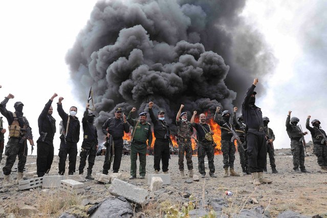 Members of Houthi security forces chant slogans near a fire, as Houthi de facto authorities burn seized narcotics, in Sanaa, Yemen on July 20, 2024. (Photo by Khaled Abdullah/Reuters)