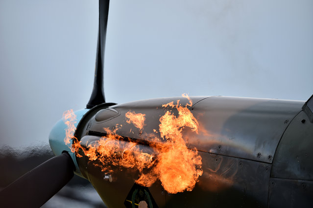 Flames are seen from the exhaust pipes of a Hurricane aircraft as the engine is started before taking off from Biggin Hill airfield in Kent, on August 18, 2015. World War II aircraft including 18 Spitfires and six Hurricanes flew over southeast England to mark the 75th anniversary of the “hardest day” of the Battle of Britain. (Photo by Ben Stansall/AFP Photo)