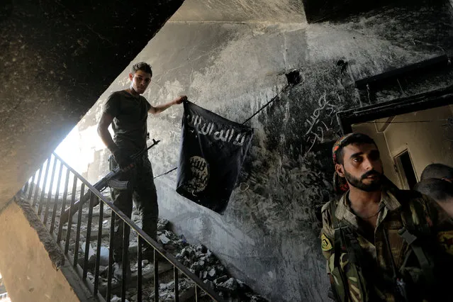 A member of the Syrian Democratic Forces calls his comrades during the fighting with Islamic State fighters in Raqqa, Syria August 14, 2017. (Photo by Zohra Bensemra/Reuters)