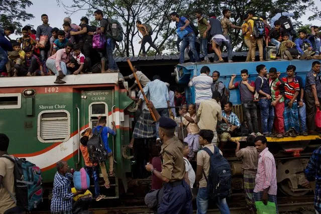 Bangladeshi Muslims climb onto the roof of an overcrowded train to travel to their hometowns ahead of of Eid al-Adha in Dhaka, Bangladesh, Friday, September 1, 2017. (Photo by Bernat Armangue/AP Photo)