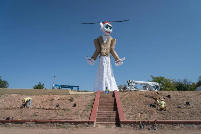 The marionette of Zozobra is pictured at Fort Marcy Park, as pyrotechnics work on rigging fireworks where it will be burned before a crowd of more than 50,000 in Santa Fe, New Mexico on September 1, 2017. Every year the Santa Fe Kiwanis club constructs the 50- foot (15- Meter) marionette to burn away all the gloom and despair of the residents of Santa Fe. (Photo by Paul Ratje/AFP Photo)