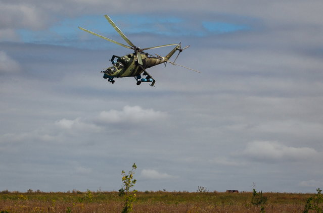 A Ukrainian Mi-24 helicopter flies close to a military camp in Kramatorsk town, near Slaviansk, Ukraine, August 19, 2014. The Ukrainian National Security and Defence Council said that separatist rebels fired on a refugee convoy near the eastern city of Luhansk. Russian Foreign Minister Sergei Lavrov said August 18 that a political settlement of the conflict in Ukraine was possible only if the government in Kiev halted its military campaign against separatist rebels in the East of the country. (Photo by Roman Pilipey/EPA)