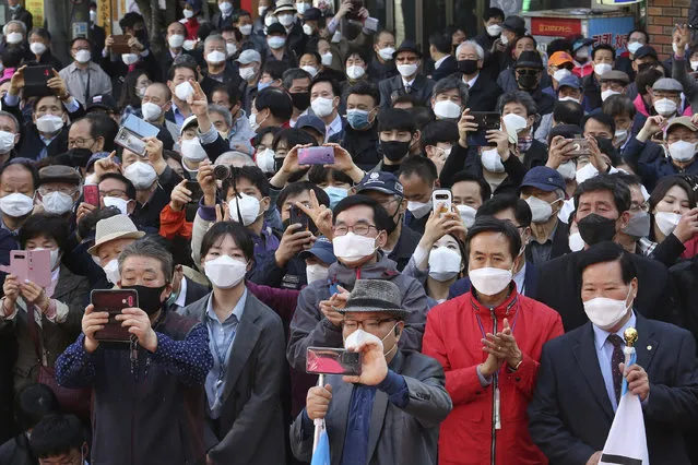 People wearing face masks to help protect against the spread of the new coronavirus listen to a speech of the main opposition United Future Party's candidate Hwang Kyo-ahn during his campaign for the upcoming parliamentary elections in Seoul, South Korea, Monday, April 13, 2020. The elections will be held on April 15 about 14,300 polling stations at all over the nation to pick lawmakers. (Photo by Ahn Young-joon/AP Photo)