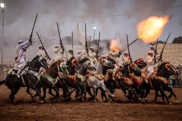 Moroccan horsemen fire their rifles during a traditional horse riding performance at a Moussem culture and heritage festival in the capital Rabat, on August 27, 2022. (Photo by Fadel Senna/AFP Photo)
