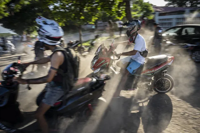 People gather on their electric scooters to spend the late afternoon showing off stunts and racing in Havana, Cuba, Friday, July 15, 2022. (Photo by Ramon Espinosa/AP Photo)