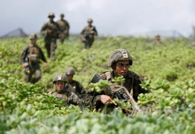U.S. Marines hike up a beach head during a simulated beach assault at Marine Corps Base Hawaii with the 3rd Marine Expeditionary Unit during the multi-national military exercise RIMPAC in Kaneohe, Hawaii, July 30, 2016. (Photo by Hugh Gentry/Reuters)