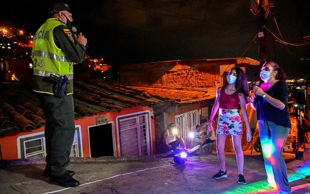A police officer sings during a serenade dedicated to Colombian “quinceanera” Andrea Moreno (2-R) for her fifteenth birthday, during a lockdown imposed by the government against the spread of the new coronavirus, in Cali, Colombia, on April 30, 2020. (Photo by Luis Robayo/AFP Photo)