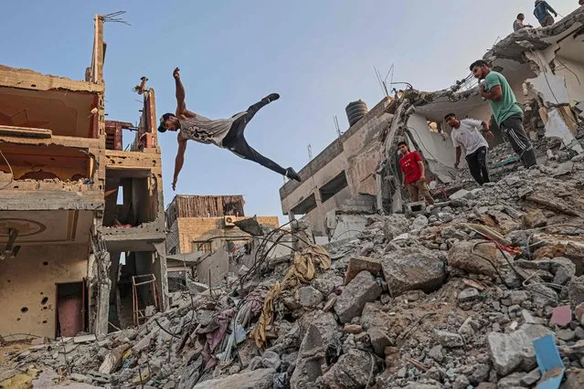 Palestinian youths practise parkour amid the rubble of buildings destroyed by Israeli airstrikes in the latest round of fighting between Israel and Palestinian militants, in Rafah in the southern Gaza Strip, on August 20, 2022. (Photo by Said Khatib/AFP Photo)
