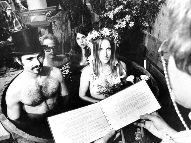 The first legal wedding ceremony in history was performed in a hot tub when Leslie Davis, 23, and Richard Bustardo, 29, got married during the Backyard Living Show in Los Angeles, March 26, 1975. The ceremony was held in a five-foot hot tub, with the bride wearing a bikini and the groom attired in swimming trunks and top hat. In background is best man Arnold Holland and bridesmaid Bonnie Heckenbach, who joined the couple in the same hot tub. Officiating is Betty Jane Shaw, left. (Photo by Harold Filan/AP Photo)