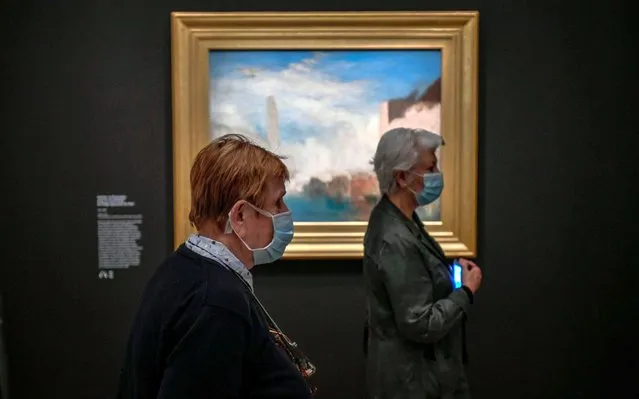 Two women wearing the face masks look at a piece as part of the exhibition of British painter Joseph Mallord William Turner “Turner – Paintings and watercolours from the Tate” at the Jacquemart-Andre Museum on the first day of the reopening in Paris on May 26, 2020, as France eases lockdown measures taken to curb the spread of COVID-19, the novel coronavirus. (Photo by Stephane de Sakutin/AFP Photo)