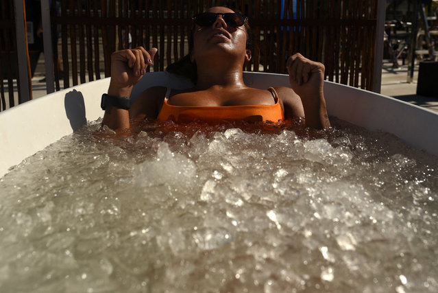 A woman takes an ice bath during a heat wave at Ipanema Beach in Rio de Janeiro, Brazil on February 6, 2025. (Photo by Tita Barros/Reuters)