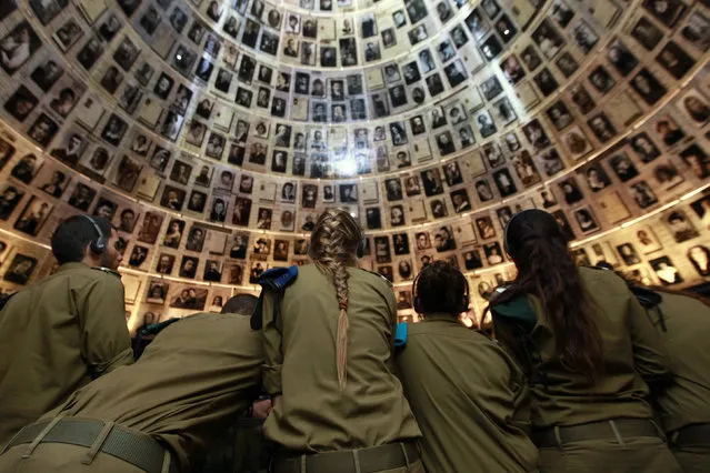 Israeli soldiers stand under pictures of Jews killed in the Holocaust, during a visit to the Hall of Names at Yad Vashem's Holocaust History Museum in Jerusalem October 25, 2010. (Photo by Baz Ratner/Reuters)