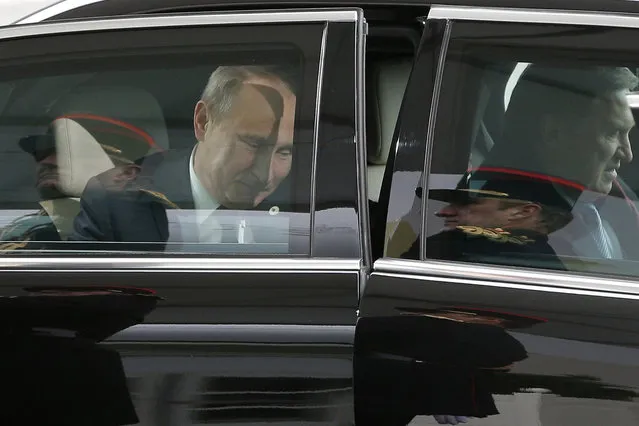 The honor guards are reflected in the limousine carrying Russian President Vladimir Putin as he arrives at the opening day of the World Climate Change Conference 2015 (COP21), on November 30, 2015 at Le Bourget, on the outskirts of the French capital Paris. World leaders opened an historic summit in the French capital with “the hope of all of humanity” laid on their shoulders as they sought a deal to tame calamitous climate change. (Photo by Christophe Ena/AFP Photo)