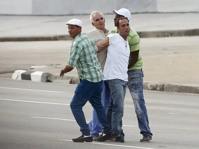 Security agents arrest a man (white shirt) who threw pamphlets during the first mass given by Pope Francis on his visit to Cuba, in Havana's Revolution Square, September 20, 2015. (Photo by Carlos Garcia Rawlins/Reuters)