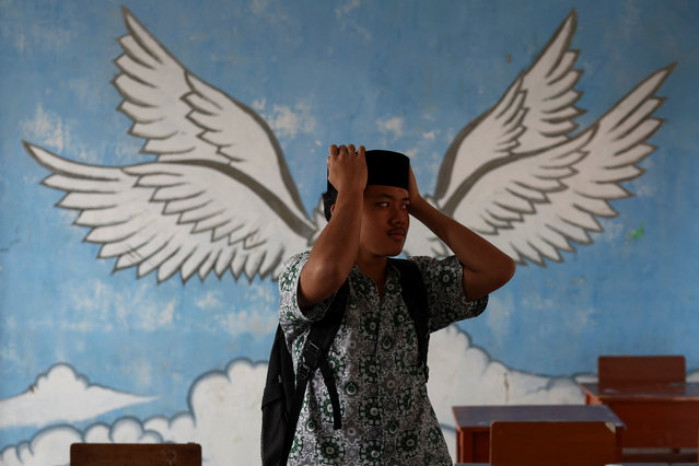 A student arranges his cap as he leaves after attending a class at Santi Asromo Islamic Boarding School in Majalengka, West Java province, Indonesia on March 6, 2025. (Photo by Willy Kurniawan/Reuters)