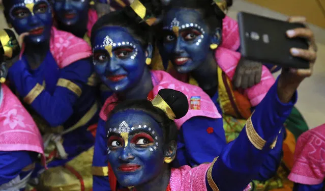 Indian students who got their faces painted in blue color take a selfie ahead of Janmashtami celebrations at a college in Mumbai, India, Tuesday, August 23, 2016. Janmashtami, is an annual celebration of the birth of the Hindu deity Krishna. (Photo by Rafiq Maqbool/AP Photo)