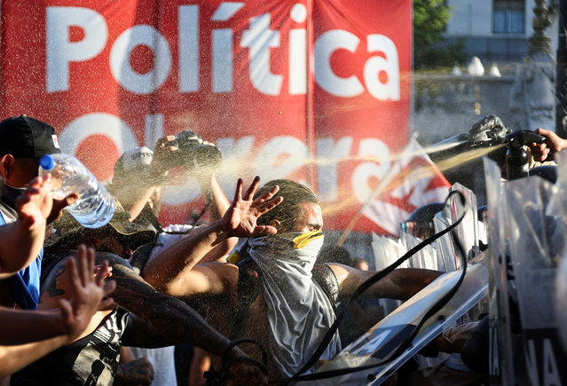 Law enforcement officers spray on demonstrators as they protest outside the National Congress on the day of the debate on Argentina's President Javier Milei's economic reform bill, known as the “omnibus bill”, in Buenos Aires, Argentina, on January 31, 2024. (Photo by Agustin Marcarian/Reuters)