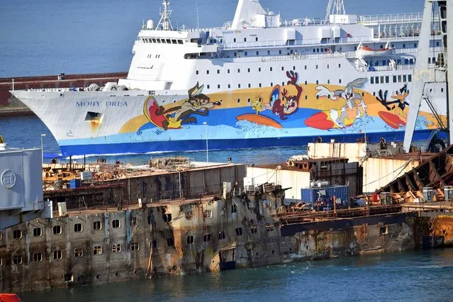 The wreck of cruise liner Costa Concordia is towed by five tugboats during its final journey inside the port of Genoa, Italy, 01 September 2016. The cruise liner, which capsized on 13 January 2012 off the Giglio Island, claiming 32 lives, will be scrapped at the dock of ship repairs in the port of Genoa. (Photo by Luca Zennaro/ANSA)