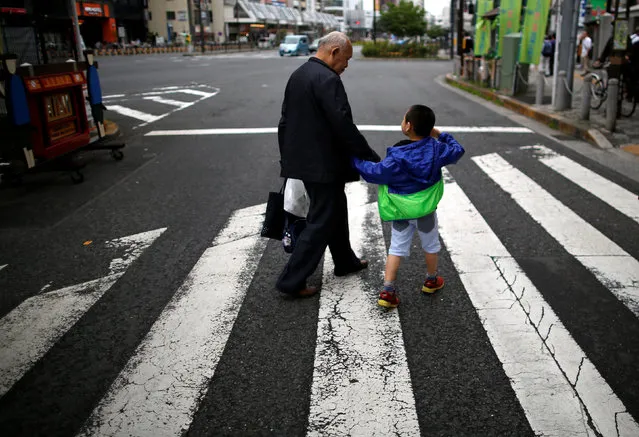 A man and his grandchild walk on the street at Tokyo's Sugamo district, an area popular among the Japanese elderly, in Japan June 15, 2016. (Photo by Issei Kato/Reuters)