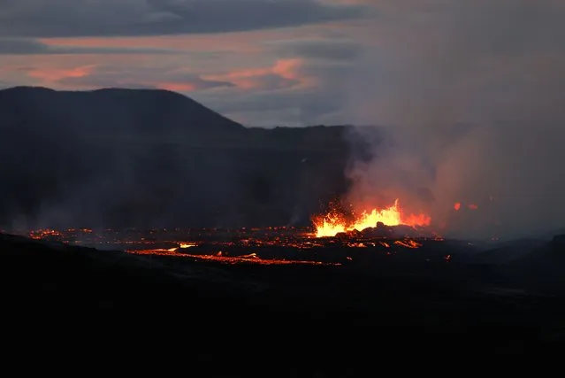 Lava spews from Fagradalsfjall volcano in Iceland as the light goes down on Wednesday August 3, 2022, which is located 32 kilometers (20 miles) southwest of the capital of Reykjavik and close to the international Keflavik Airport. (Photo by Brynjar Gunnarsson/AP Photo)