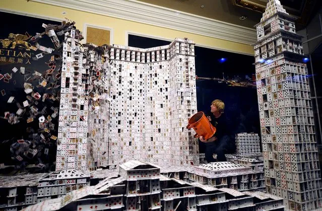 U.S. “cardstacker” Bryan Berg knocks down his Guinness World Record for the largest house of freestanding playing cards, a replica of the Venetian Macao, the Plaza and Sands Macao casino and hotel buildings in Macau on March 20, 2010. Berg's promotional attempt took 44 days and used a total of 218,792 playing cards. (Photo by Dale de la Rey/AFP Photo)