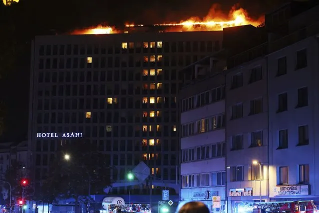 Flames burst from the roof of a hotel in downtown Düsseldorf, Germany on October 13, 2022. (Photo by David Young/AP Photo)