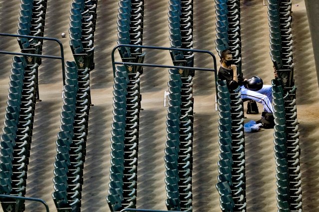 A lone foul ball sits in an aisle as an Arizona Diamondbacks ballboy watches from the stands during the sixth inning of a baseball game against the San Diego Padres Saturday, August 15, 2020, in Phoenix. (Photo by Matt York/AP Photo)