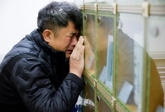 Cho Gi-Dong, who lost his 24-year-old daughter Ye-jin in the deadly Halloween crush in Seoul a month ago, cries as he visits a charnel house where her remains are kept in Daejeon, South Korea on November 29, 2022. (Photo by Heo Ran/Reuters)
