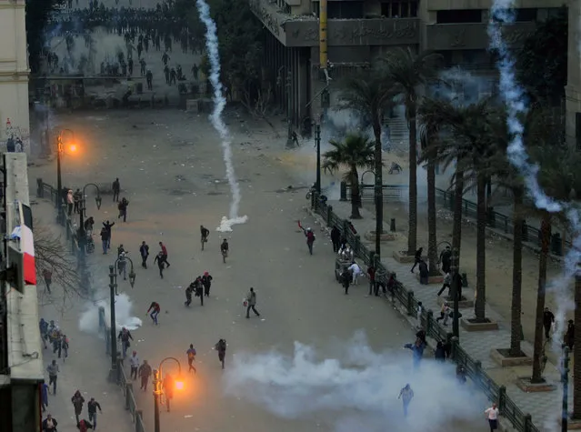 Protesters flee from tear gas fired by riot police during clashes after protesters removed a concrete barrier at Qasr al-Aini Street near Tahrir Square in Cairo, on January 24, 2013. (Photo by Mohamed Abd El Ghany/Reuters/The Atlantic)