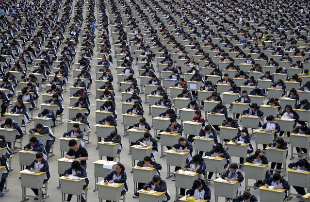 Students take an examination on an open-air playground at a high school in Yichuan, Shaanxi province April 11, 2015. More than 1,700 freshmen students took part in the exam on Saturday, which was the first attempt by the school to take it in open-air. The school said the reasons was due to the insufficient indoor space and also that it could be a test of the students' organizing capacity, local media reported. (Photo by Reuters/Stringer)