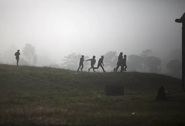 Children are silhouetted as they run along the hills during the Shikali festival at Khokana village in Lalitpur, Nepal October 19, 2015. (Photo by Navesh Chitrakar/Reuters)