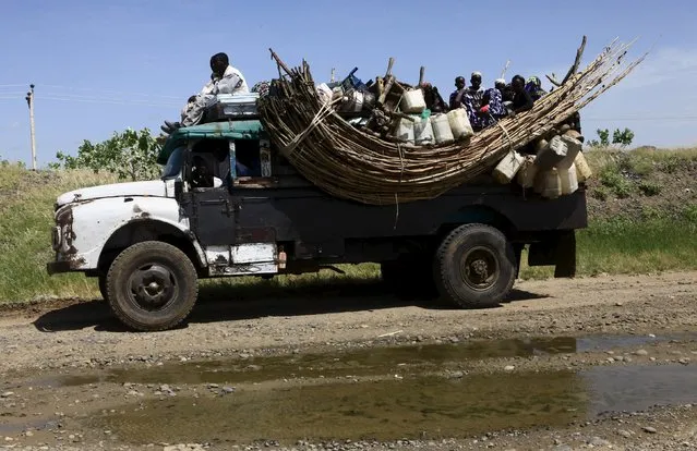 Displaced people ride on a truck during a visit by a European Union delegation, at an IDP camp in Azaza, east of Ad Damazin, capital of Blue Nile state, October 21, 2015. (Photo by Mohamed Nureldin Abdallah/Reuters)