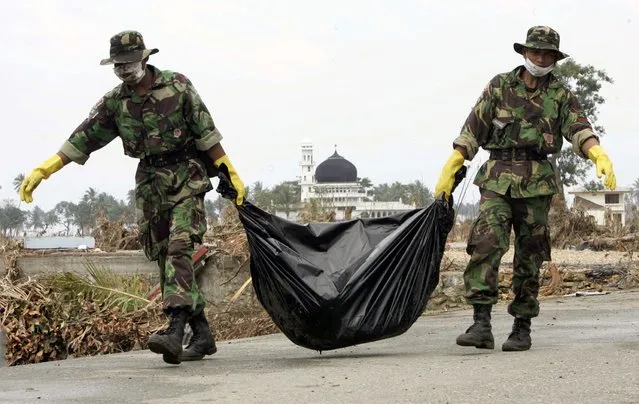 Indonesian soldiers remove a body from the village of Simpang Lima, one of thousands killed in the area, on the outskirts of Banda Aceh on the Indonesian island of Sumatra in this January 1, 2005 file photo. (Photo by Darren Whiteside/Reuters)