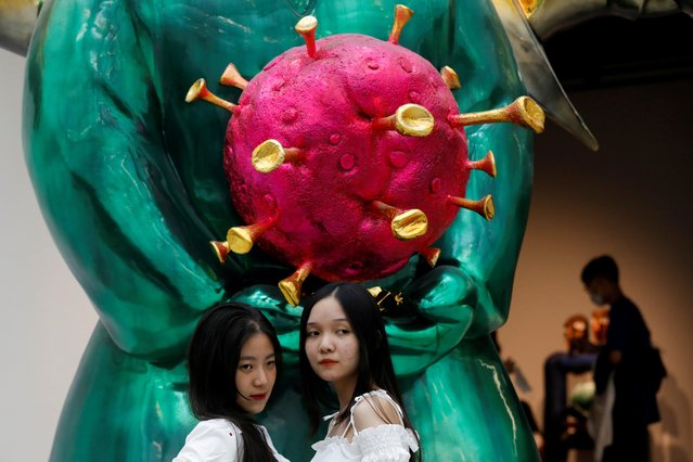 Visitors pose near the sculpture “Land Genie” by artist Pham Thai Binh, which is shaped as a coronavirus, during an art exhibition at Vincom Center for Contemporary Art in Hanoi, Vietnam on October 12, 2020. (Photo by Reuters/Kham)