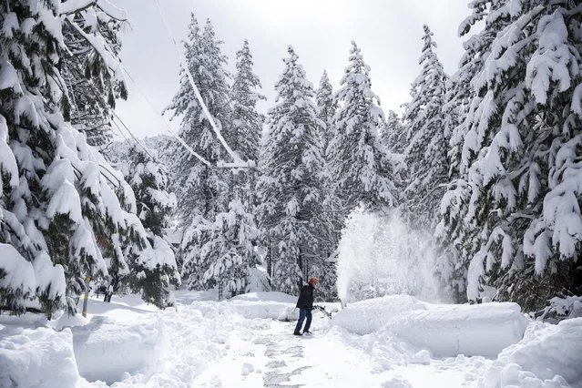 A resident clears snow from the road during a break from the storm in Pine Mountain Club, Calif., on Friday, February 25, 2023, after a rare blizzard in Southern California dumped significant snow overnight. (Photo by Jenna Schoenefeld/The New York Times)
